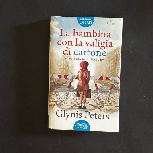 La bambina con la valigia di cartone