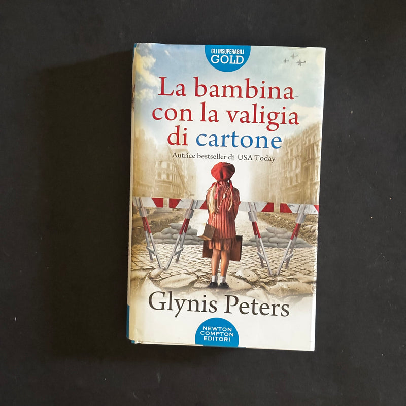 La bambina con la valigia di cartone